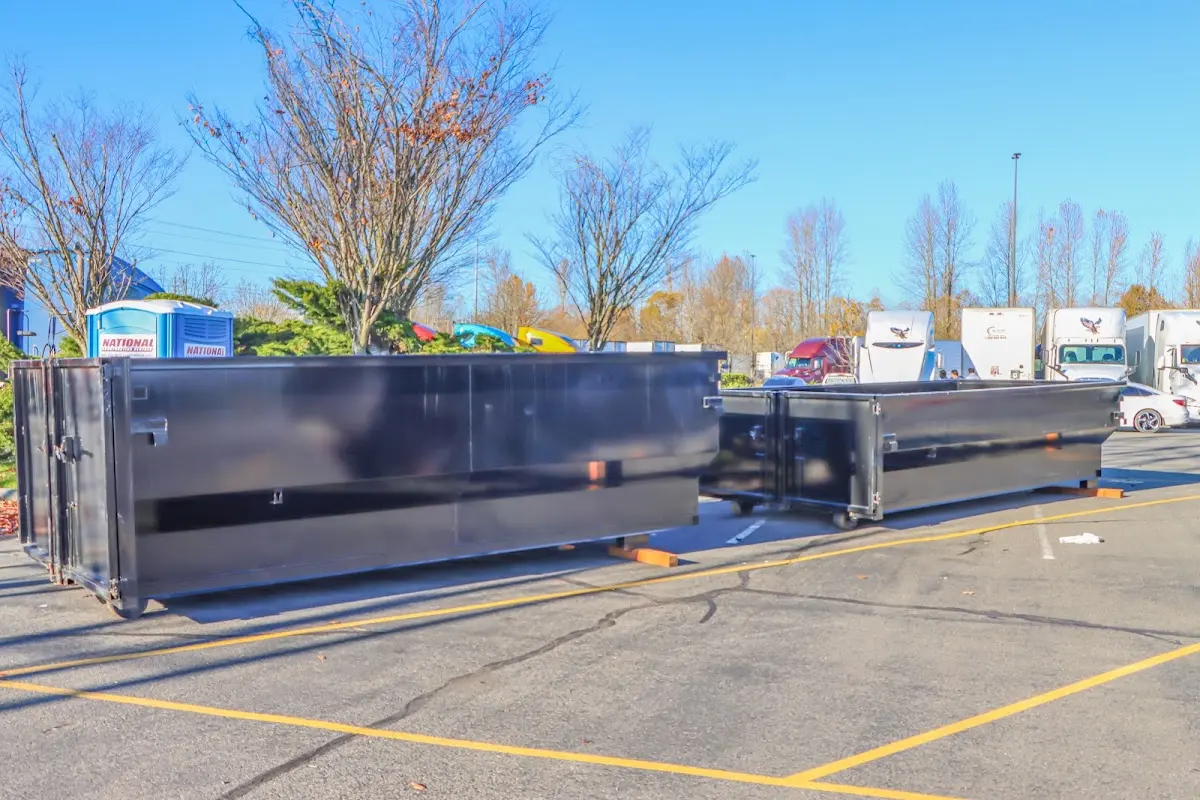 Professional dumpster rental service with roll-off container on residential driveway in Homeland